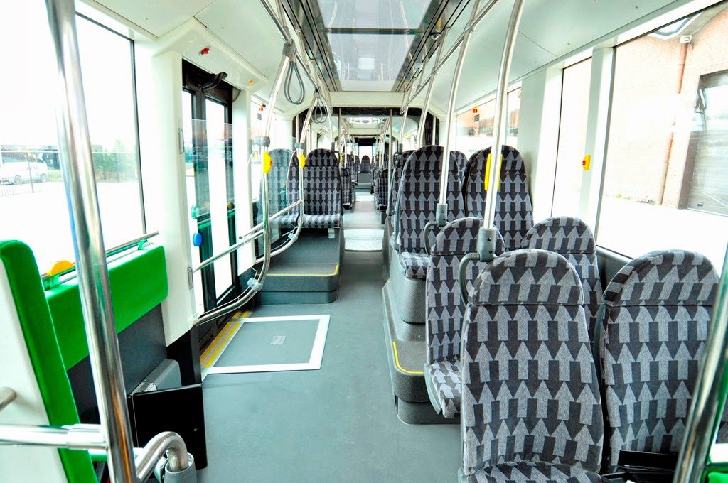 Wnętrze nowoczesnego autobusu hybrydowego Van Hool Exqui.City CNG z fotelami pasażerów
