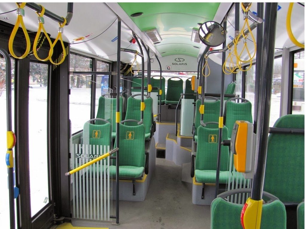 Wnętrze autobusu Solaris Urbino 12 CNG z zielonymi siedzeniami i żółtymi poręczami