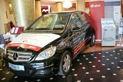 Czarny Mercedes-Benz B-Klasa z reklamą e.on na stoisku targowym w hotelowym lobby