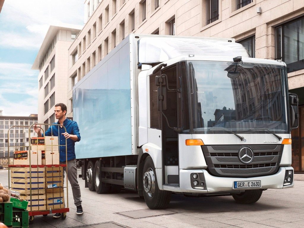 Mercedes Econic NGT załadowujący śmieci z pomocą systemu załadowczego