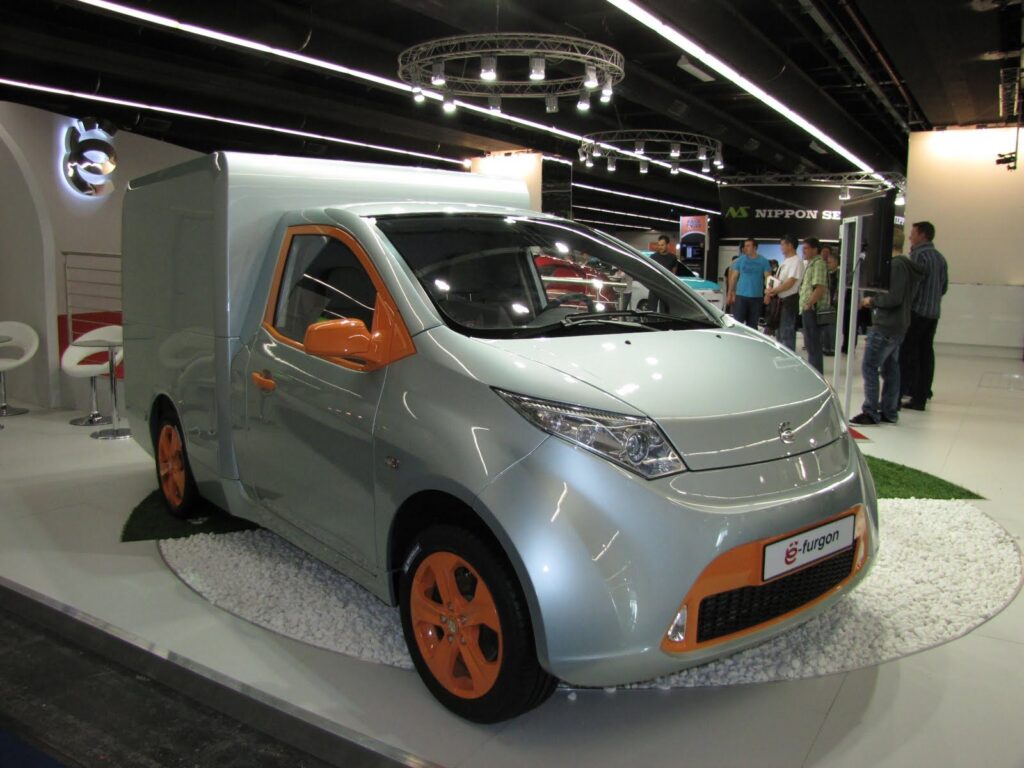 Yo-Mobile e-furgon biały i pomarańczowy na targach, prototyp pojazdu CNG