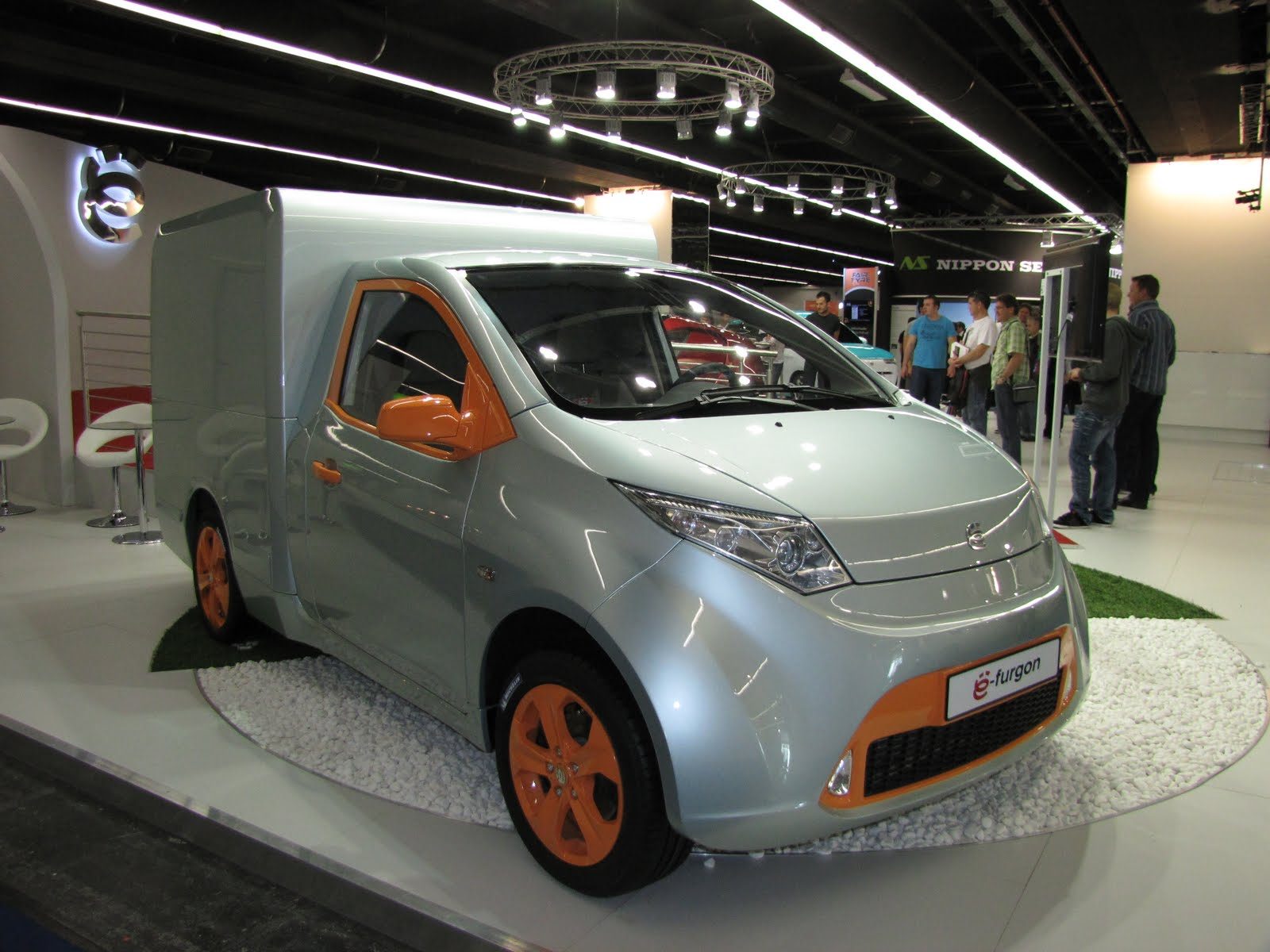 Yo-Mobile e-furgon biały i pomarańczowy na targach, prototyp pojazdu CNG