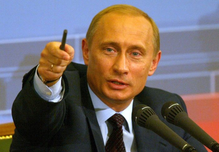 Prezydent Putin przemawia do mikrofonu na konferencji CNG