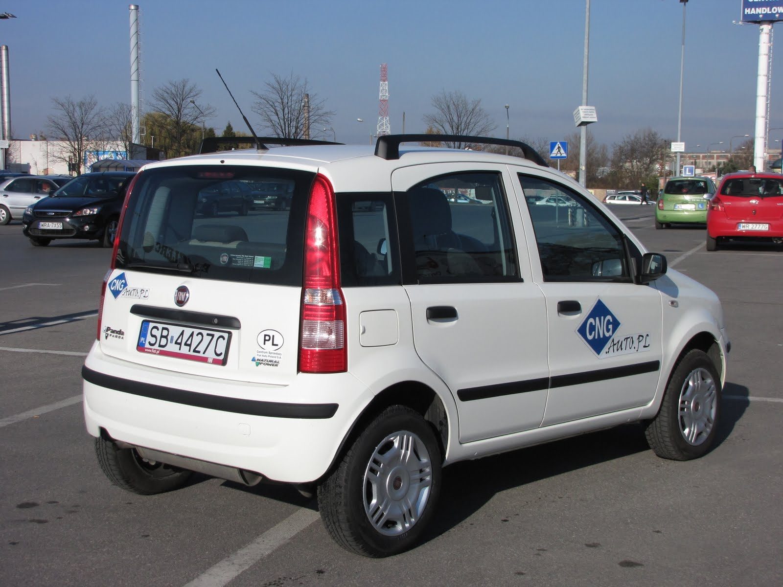 Biały Fiat Panda Natural Power z naklejką CNG.auto.pl na parkingu, widok od tyłu z tablicą SB 4427C