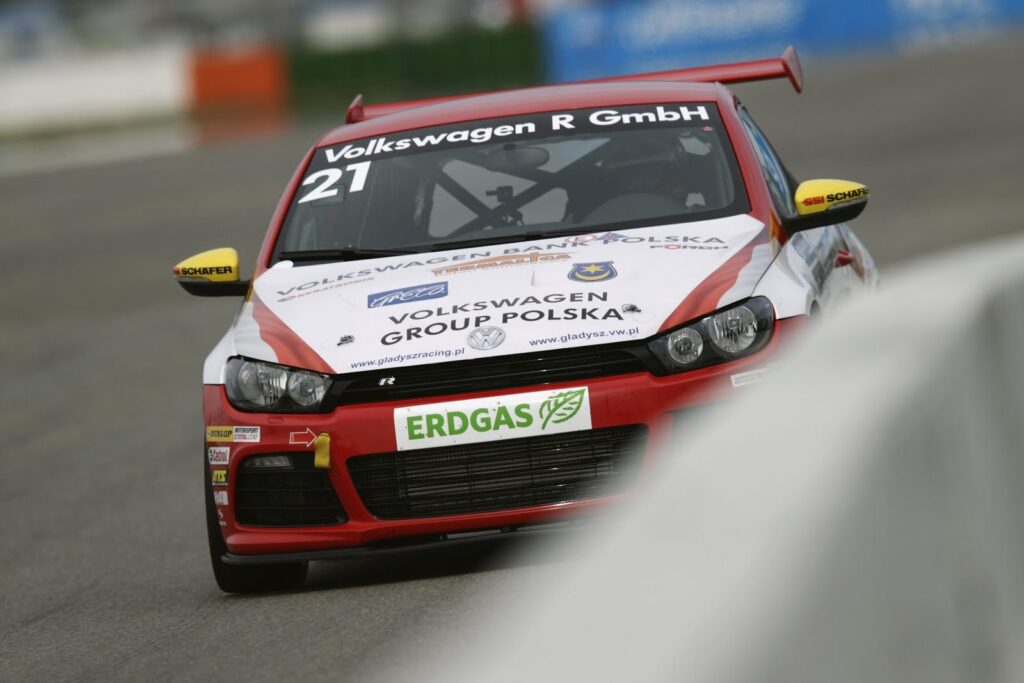 Kierowca Gładysz przy czerwonym Volkswagenie Scirocco Cup zasilanym CNG