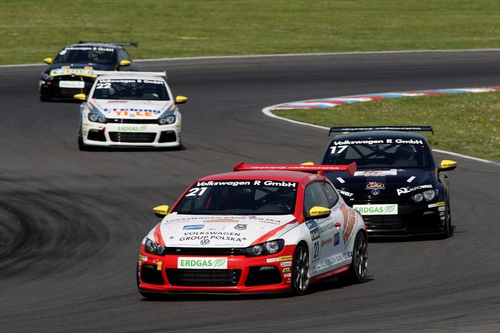 Trzej kierowcy na podium wyścigów Volkswagen Scirocco Cup w żółtych czapkach