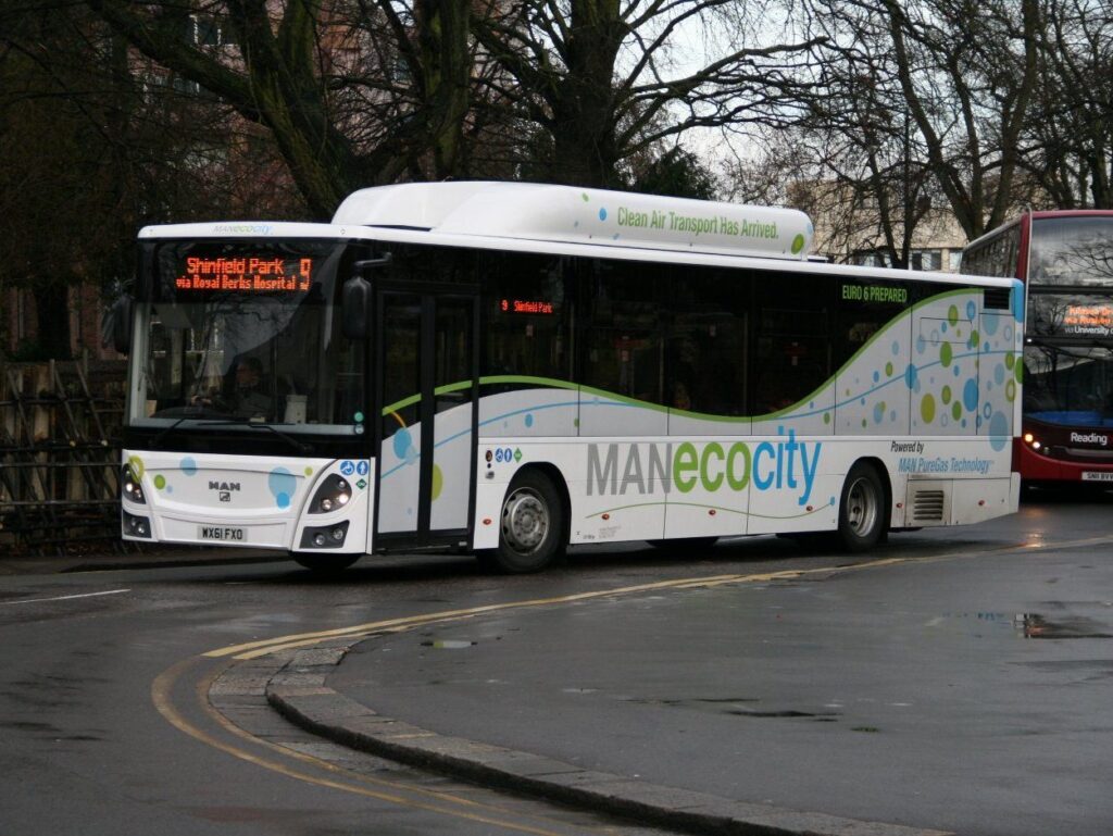 Biały autobus MAN Lion's City ecocity z napisem Clean Air Transport Has Arrived na trasie Shinfield Park w Reading